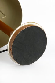 Nahaufnahme der Unterseite einer Tischleuchte mit runder, schwarzer Basis und braunem Stiel.