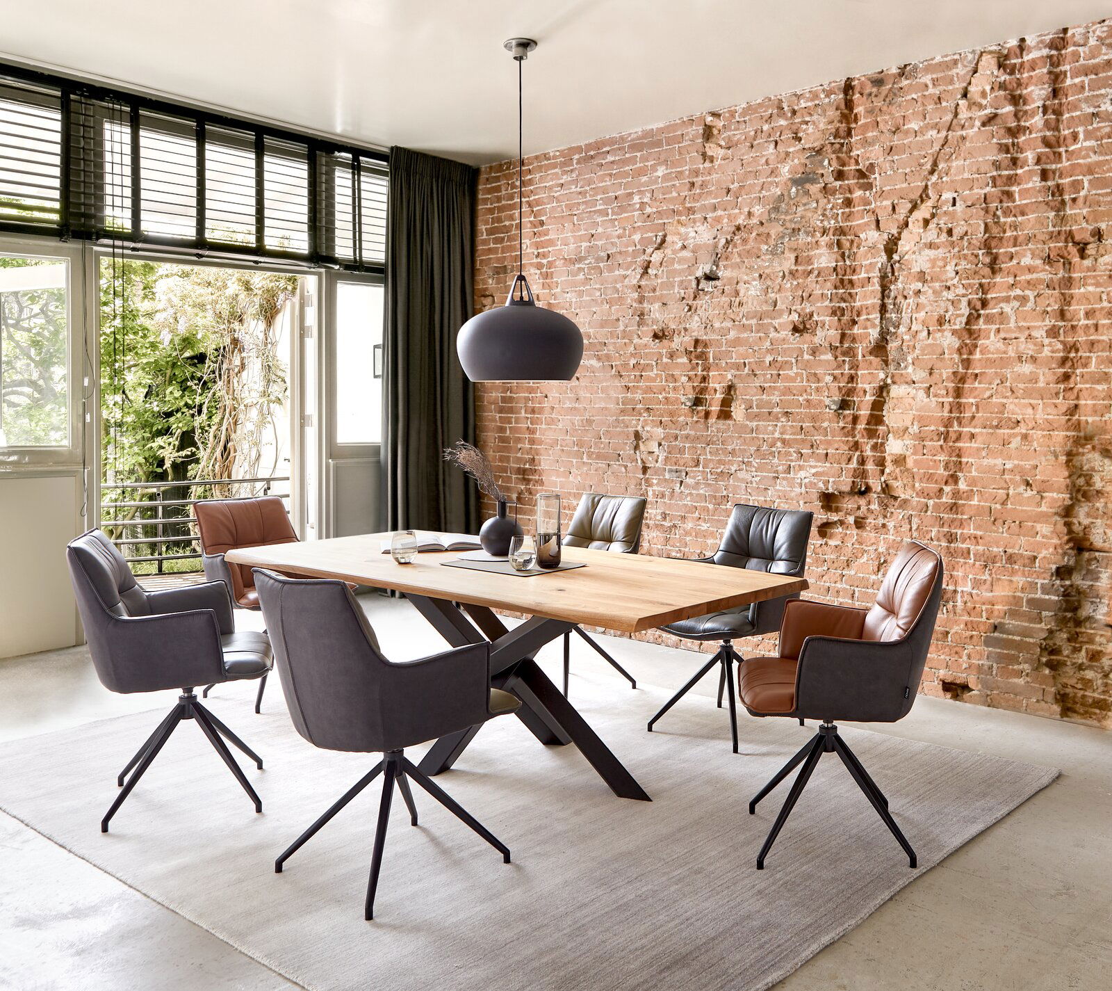 Novel Sessel OSAKA 3.0 Esszimmer mit modernem Tisch und Sesseln vor einer Ziegelwand, Perspektive von schräg vorne