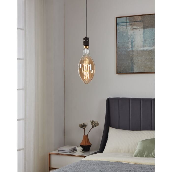 Moderne hanglamp met amberkleurige Edison-gloeilamp en zwart snoer boven een bed in een minimalistische slaapkamer, frontaal perspectief.