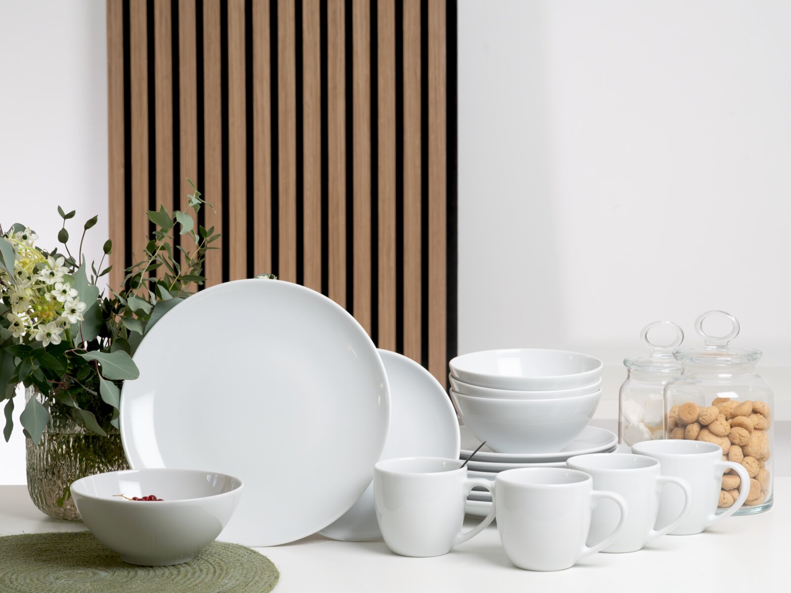 creaTable Kombiservice 16-tlg BISTROT Weißes Porzellan-Geschirrset mit Tellern, Schalen und Tassen auf Tisch arrangiert, frontal in leicht erhöhter Perspektive aufgenommen.
