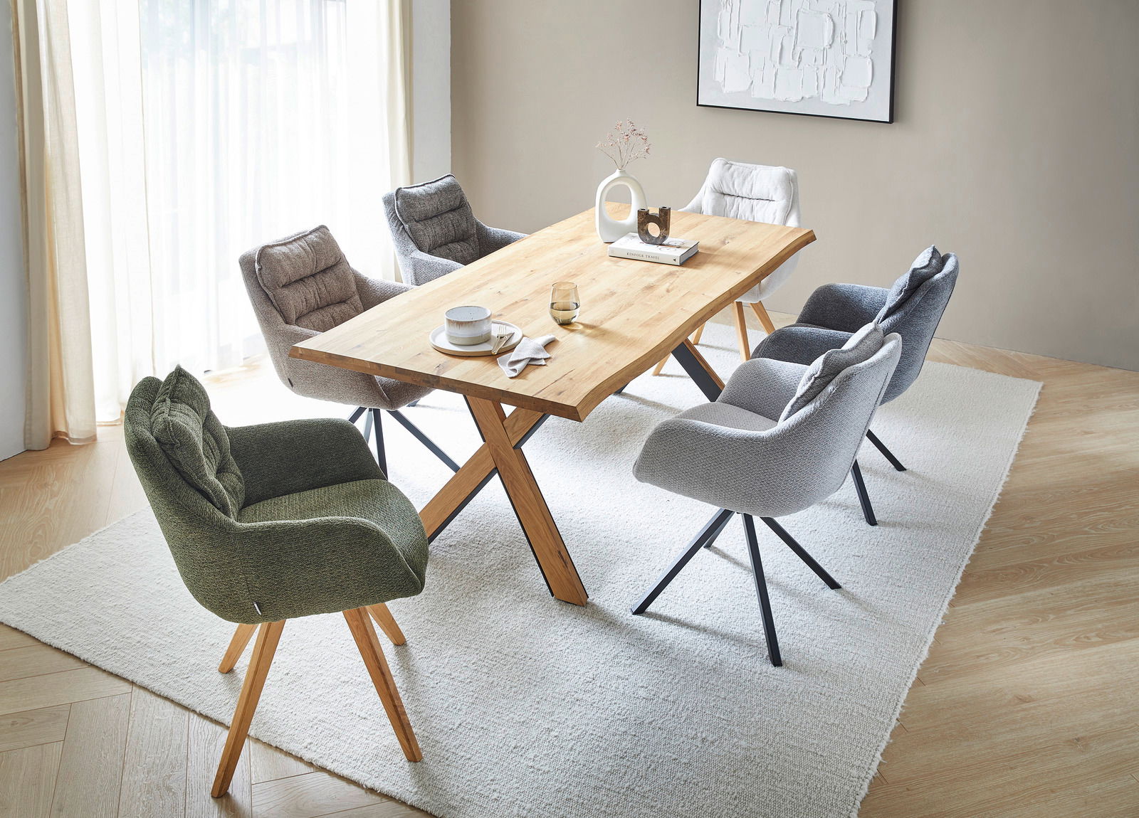 Linea Natura Esstisch X-RAY Esszimmer mit einem Holztisch und mehreren gepolsterten Armlehnstühlen in verschiedenen Farben, aus der Vogelperspektive betrachtet.