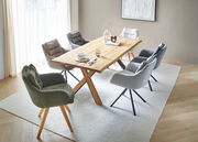 Esszimmer mit einem Holztisch und mehreren gepolsterten Armlehnstühlen in verschiedenen Farben, aus der Vogelperspektive betrachtet.