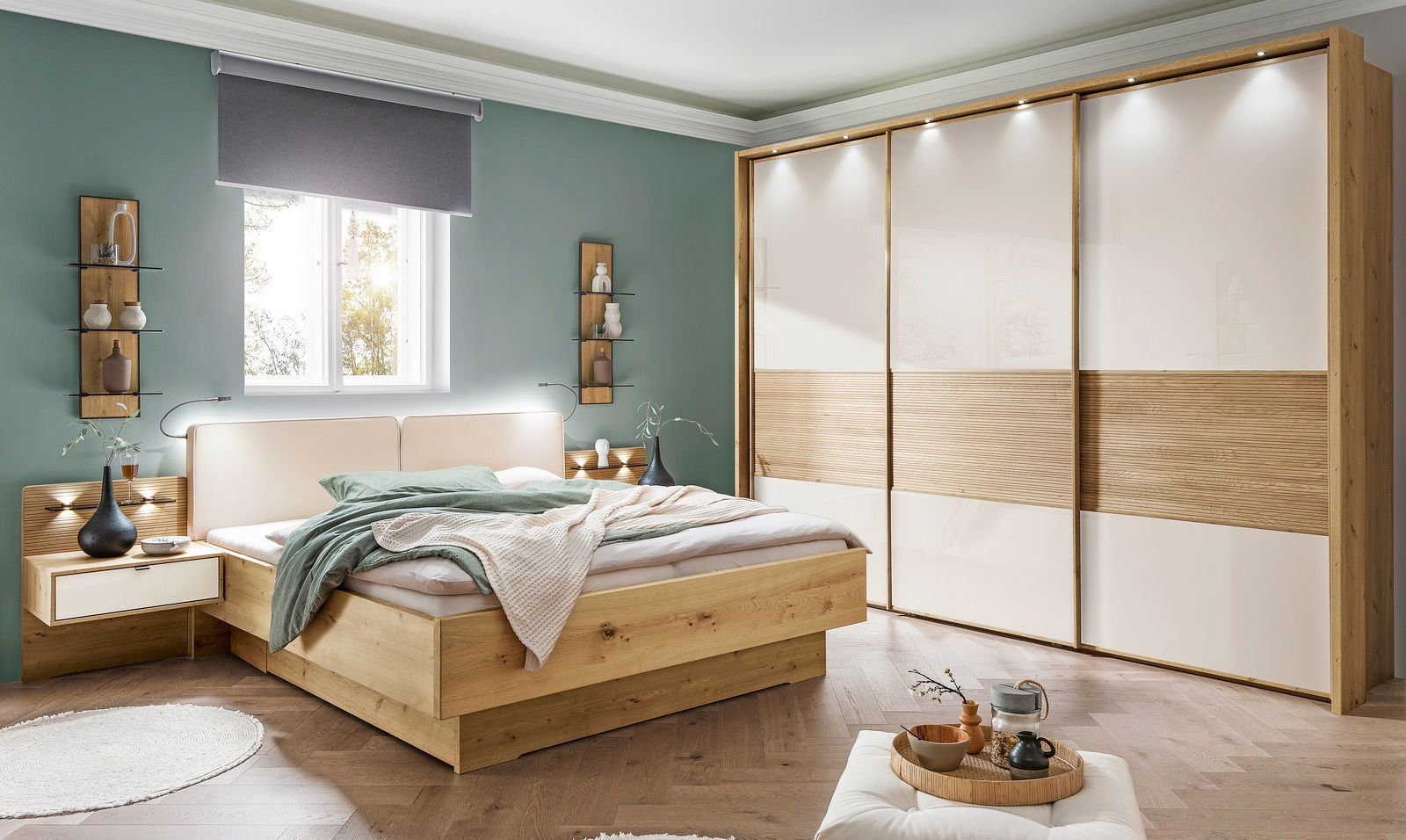 Moderner Schwebetürenschrank mit drei Türen in Holzoptik und weißen Paneelen, beleuchtet von oben. Perspektive: Frontalansicht im Schlafzimmer.