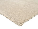 Beige Uni-Teppich aus seitlicher Perspektive fotografiert, zeigt die weiche Textur und die Kantenverarbeitung.