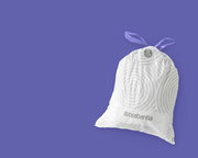 Ein weißer Müllbeutel der Marke Brabantia mit lila Zugband, auf einer lila Hintergrundfläche, von vorne betrachtet.