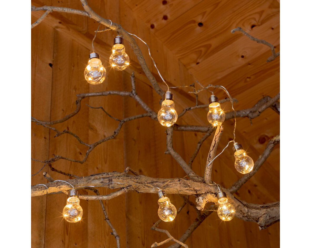 Solarbetriebene Lichterkette mit Glühbirnen an einem Ast, seitliche Perspektive