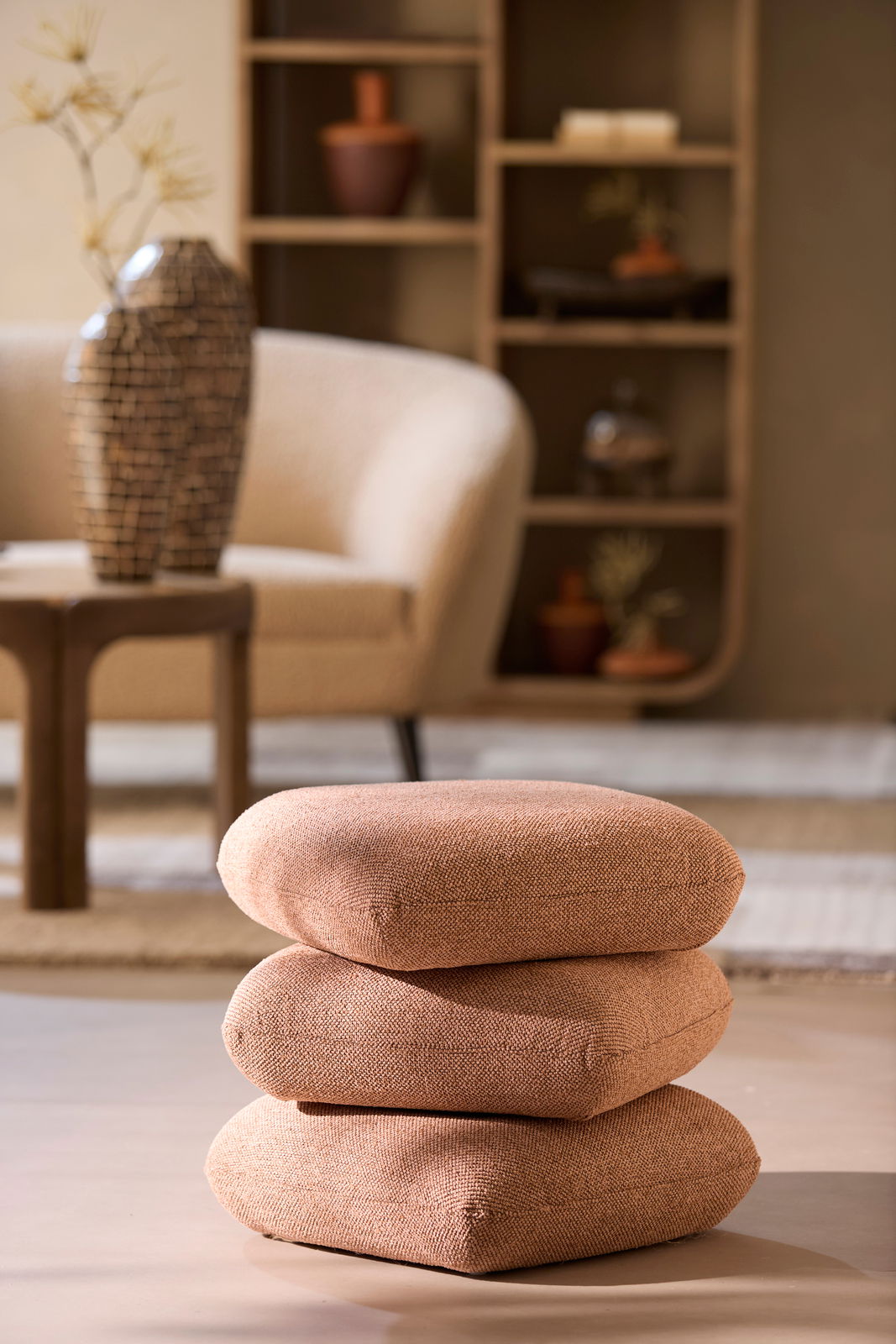 Light&Living Sitzpuff LAURIE Ein Sitzpuff in warmem Braunton, bestehend aus drei übereinander gestapelten Kissen, in einem stilvoll eingerichteten Wohnzimmer. Perspektive: seitlich.