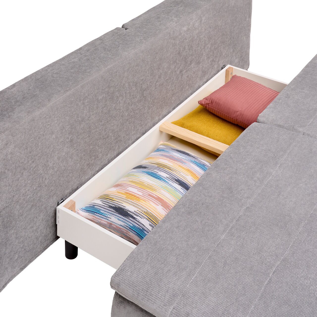 Boxspring-functiebank in grijze stof met een open opberglade, gevuld met kleurrijke kussens, gezien vanuit vogelperspectief.