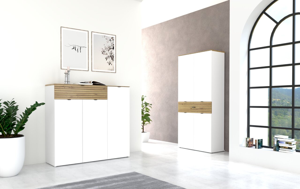 Moderne Garderobenmöbel in einem hellen Raum mit großen Fenstern, bestehend aus einem weißen Hängeschrank und einem hohen Schuhschrank mit Holzdetails, seitliche Perspektive.