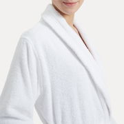 Nahaufnahme eines weißen Bademantels mit Schalkragen, getragen von einer Person, die von der Seite zu sehen ist.