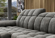 Graues, gepolstertes Longchair-Sofa in einer modernen Wohnzimmerumgebung, seitliche Perspektive.