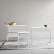 Drei weiße Möbelstücke auf einem Teppich vor einer hellen Wand, bestehend aus einer Kommode, einem Konsolentisch und einer Nachtkonsole, frontal betrachtet.
