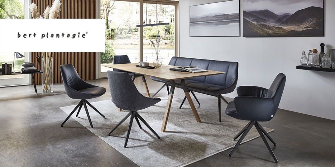 Moderner Essbereich mit einem hellen Holztisch, umgeben von dunkelgrauen Stühlen und einer Bank und zwei großen Gemälden an der Wand.