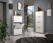 Moderner Schuhschrank in Weiß mit Holzdetails, geöffnet, in einem stilvollen Raum mit Treppe im Hintergrund, seitliche Perspektive.