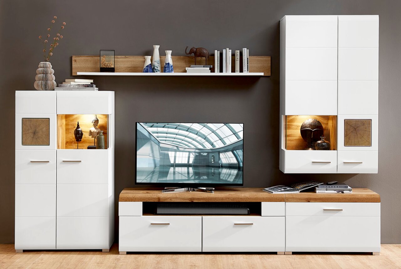 Moderne Wohnwand in Weiß mit Holzdetails, bestehend aus einem TV-Board, zwei Vitrinen und einem Wandregal, frontal betrachtet.