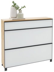 Moderne Kommode mit drei weißen Schubladen, schwarzem Rahmen und Holzplatte, dekoriert mit Vasen und Buch, in leicht schräger Frontansicht von links