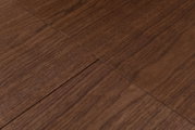 Close-up schuin bovenaanzicht van een bruin houten tafelblad met zichtbare nerf en naad tussen de planken