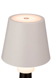 Nahaufnahme einer modernen Akku-Tischleuchte mit weißem Lampenschirm und einem Touch-Schalter auf der Oberseite.