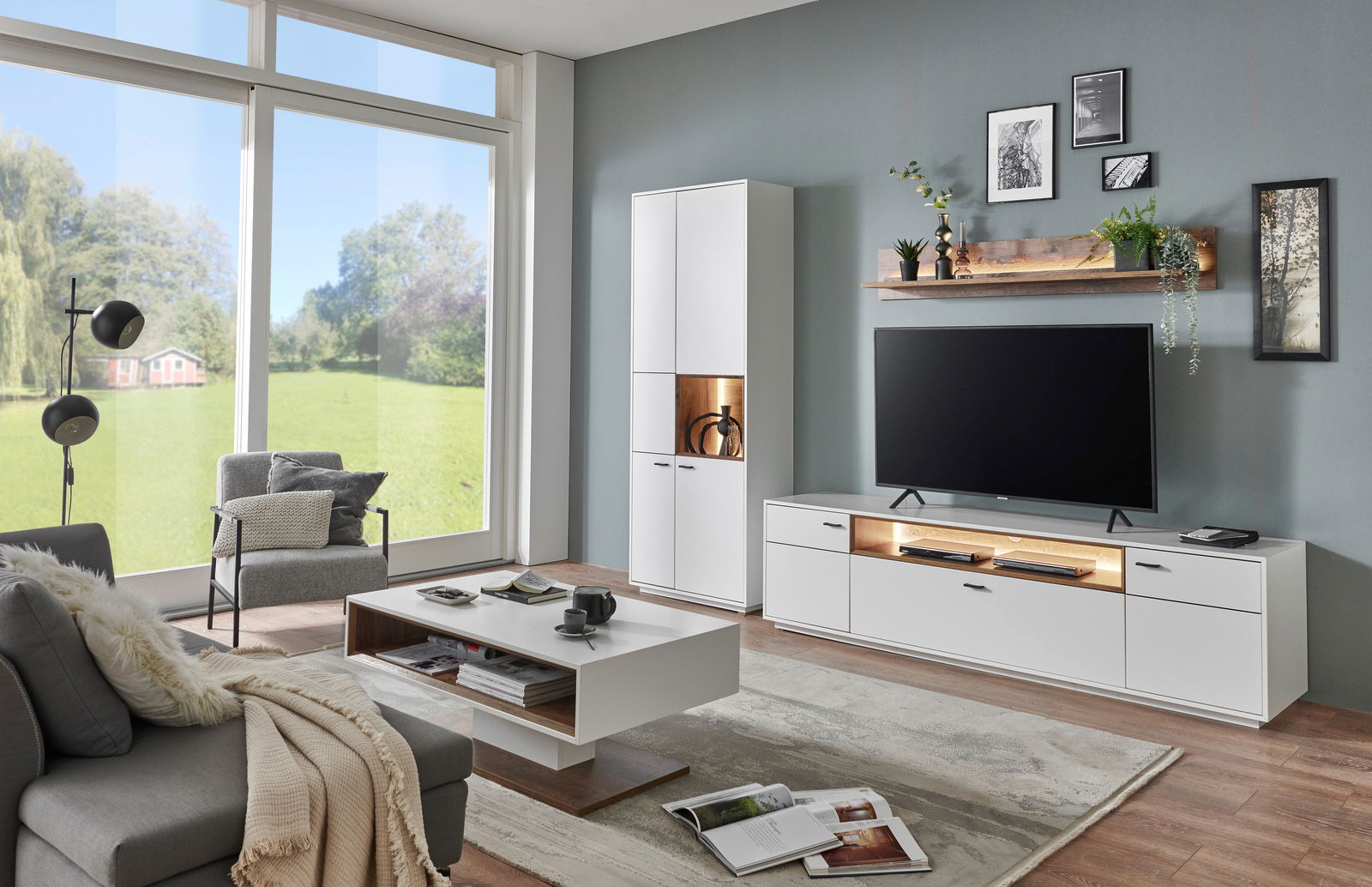 Moderne Wohnzimmer-Wandkombination in Weiß mit TV-Schrank, hohem Schrank und Wandregal, seitliche Perspektive