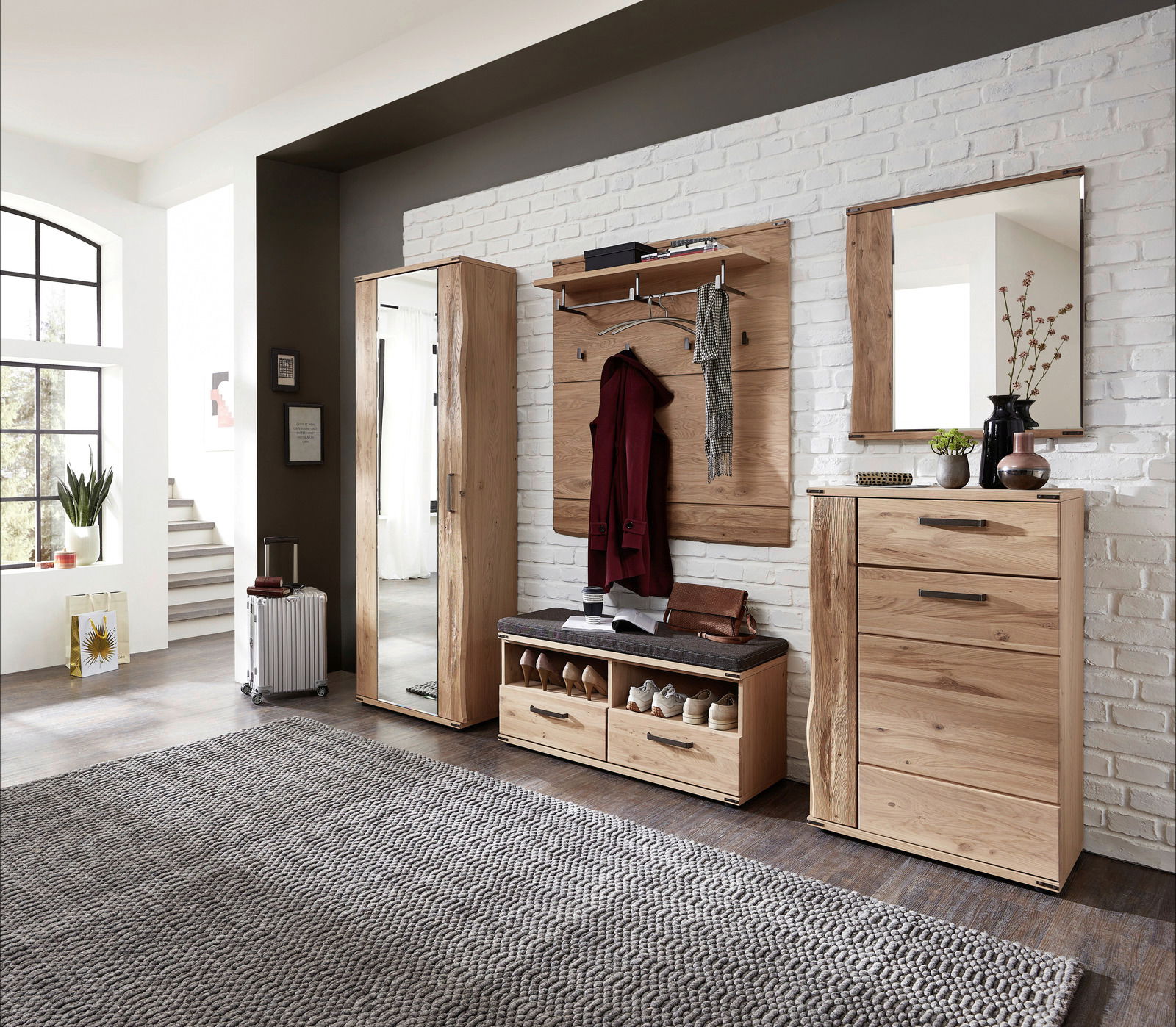 Moderne Garderobenkombination aus Holz in einem hellen Raum, bestehend aus Garderobenschrank, Schuhschrank, Garderobenpaneel, Spiegel und Garderobenbank. Frontalansicht.