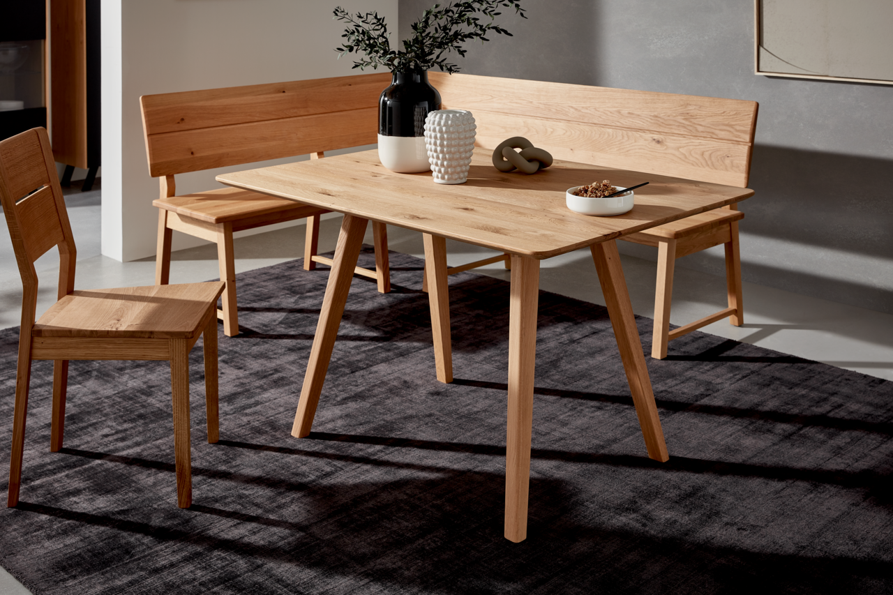 Eckbank aus Holz mit Tisch und Stühlen in einem modernen Esszimmer, seitliche Perspektive