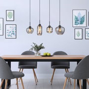 Moderne Hängeleuchte mit vier Glaskugeln in einem Esszimmer, seitliche Perspektive