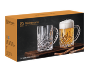 Verpackung des Bierkrug Sets Noblesse mit zwei Kristallglaskrügen, einer leer und einer mit Bier gefüllt, auf einem Holzbrett. Perspektive: seitlich.