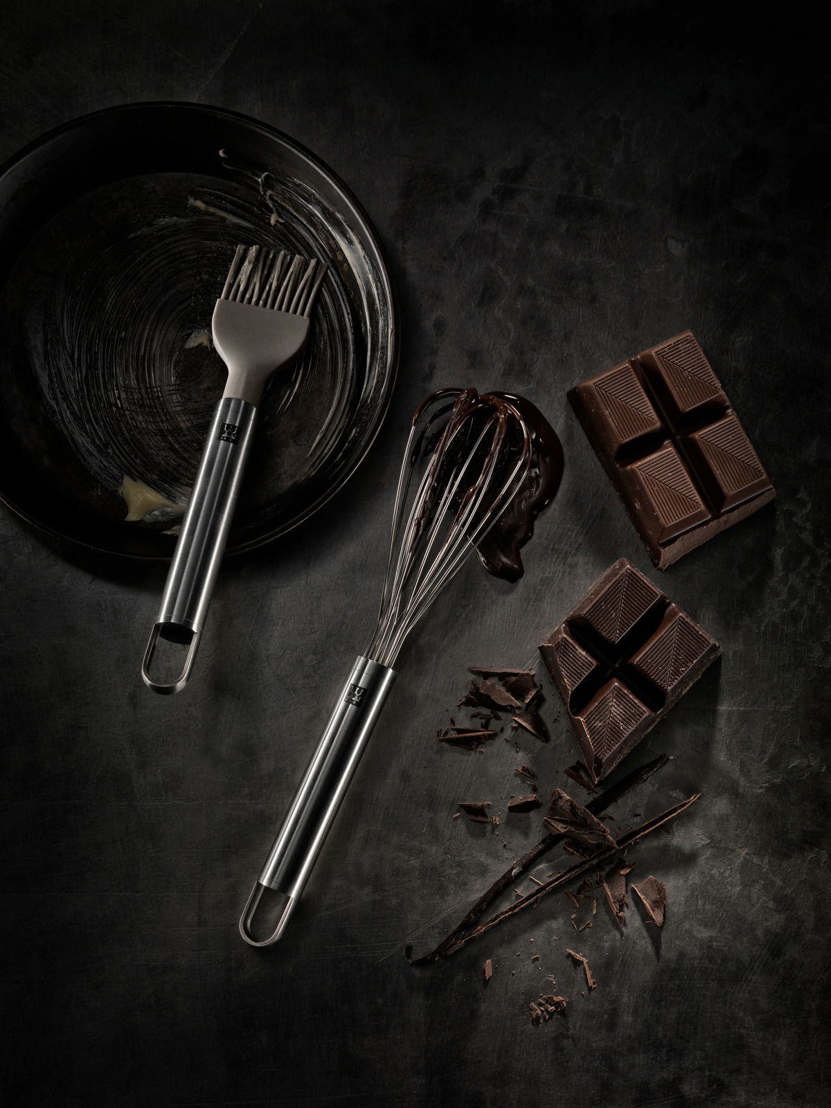 ZWILLING Schneebesen klein PRO Kleiner Schneebesen aus Edelstahl, von oben fotografiert, neben einer Pfanne mit Backpinsel und Schokoladenstücken.