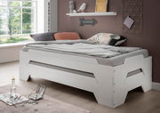 Stapelbett in modernem Design, seitliche Perspektive, mit gemütlicher Bettwäsche und dekorativen Kissen in einem hellen Raum.