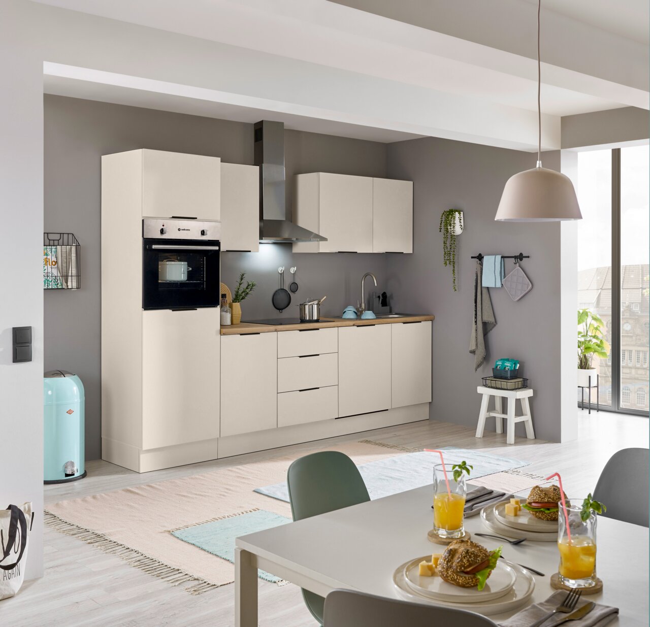Moderne Küchenzeile in hellem Design mit eingebautem Backofen, Dunstabzugshaube und Spüle, seitliche Perspektive