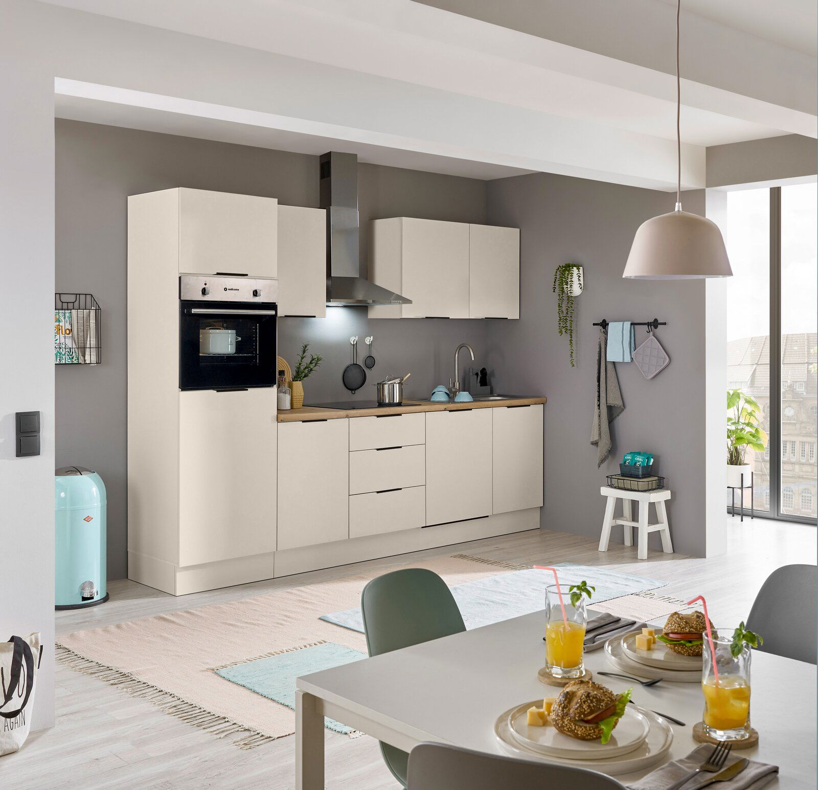 Moderne Küchenzeile in hellem Design mit eingebautem Backofen, Dunstabzugshaube und Spüle, seitliche Perspektive