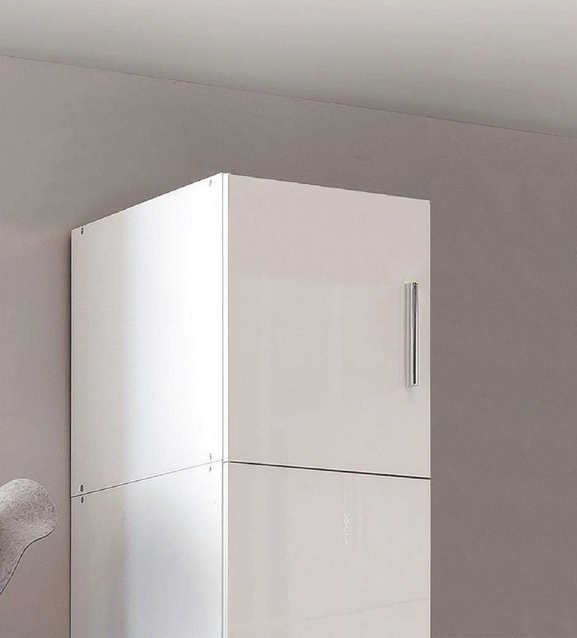 Weißer Schrankaufsatz mit glänzender Oberfläche und silbernem Griff, seitliche Perspektive