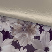 Wendebettwäsche mit floralem Muster in Nahaufnahme, eine Seite in Beige, die andere mit großen Blumen auf dunklem Hintergrund.