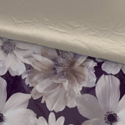 Omkeerbaar beddengoed met bloemenpatroon in close-up: de ene kant is beige, de andere kant heeft grote bloemen op een donkere achtergrond.