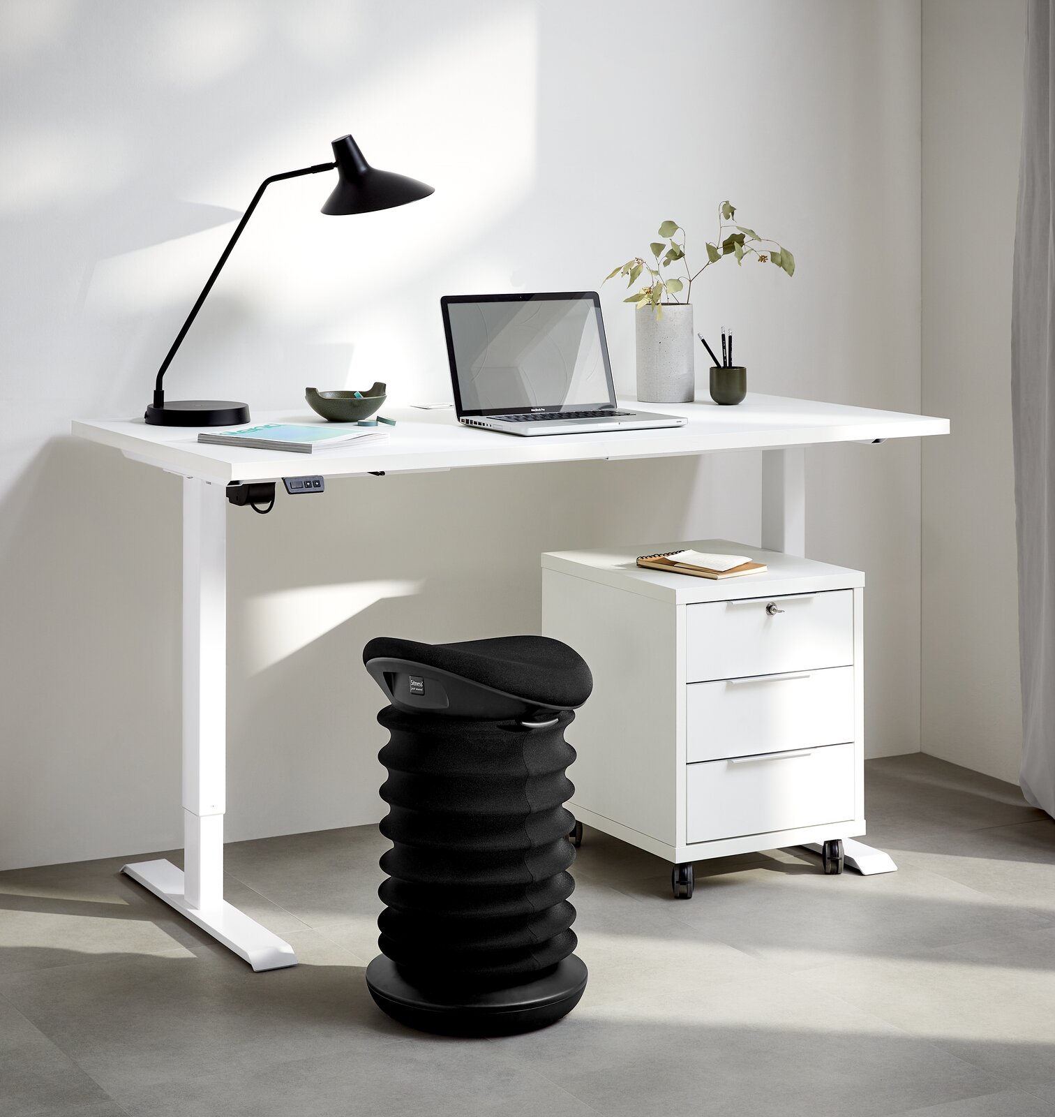 Schwarzer Schwinghocker in einem modernen Büro, seitliche Perspektive