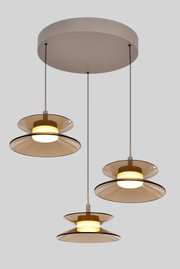 Moderne hanglamp met drie warmwitte lichtbronnen, amberkleurige glazen schijven en ronde beige plafondkap, vanuit schuin onderaanzicht.
