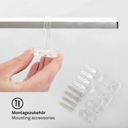 Montagezubehör für LED-Deckenleuchte, Nahaufnahme von Hand, die ein transparentes Befestigungselement hält, mit Schrauben und Dübeln im Hintergrund.