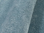 Nahaufnahme eines blauen Uni-Teppichs mit weicher Textur, seitliche Perspektive