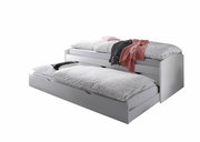 Tandemliege in seitlicher Perspektive mit zwei übereinanderliegenden Betten, das untere Bett ist teilweise ausgezogen, beide mit gemusterten Bettdecken und Kissen.