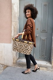 Vrouw in een bruine blazer draagt een Carrybag met luipaardprint, zijaanzicht