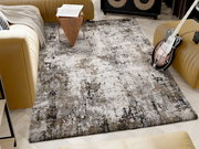 Designer Teppich in einem modernen Wohnzimmer, umgeben von einem gelben Sofa, einem Holztisch mit Zeitschriften und einer E-Gitarre. Perspektive von oben.