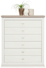 Weiße Kommode mit sechs Schubladen, dekoriert mit einer Pflanze, einer Eulenfigur und einem Korb auf der Oberseite, Frontalansicht.