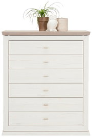 Weiße Kommode mit sechs Schubladen, dekoriert mit einer Pflanze, einer Eulenfigur und einem Korb auf der Oberseite, Frontalansicht.