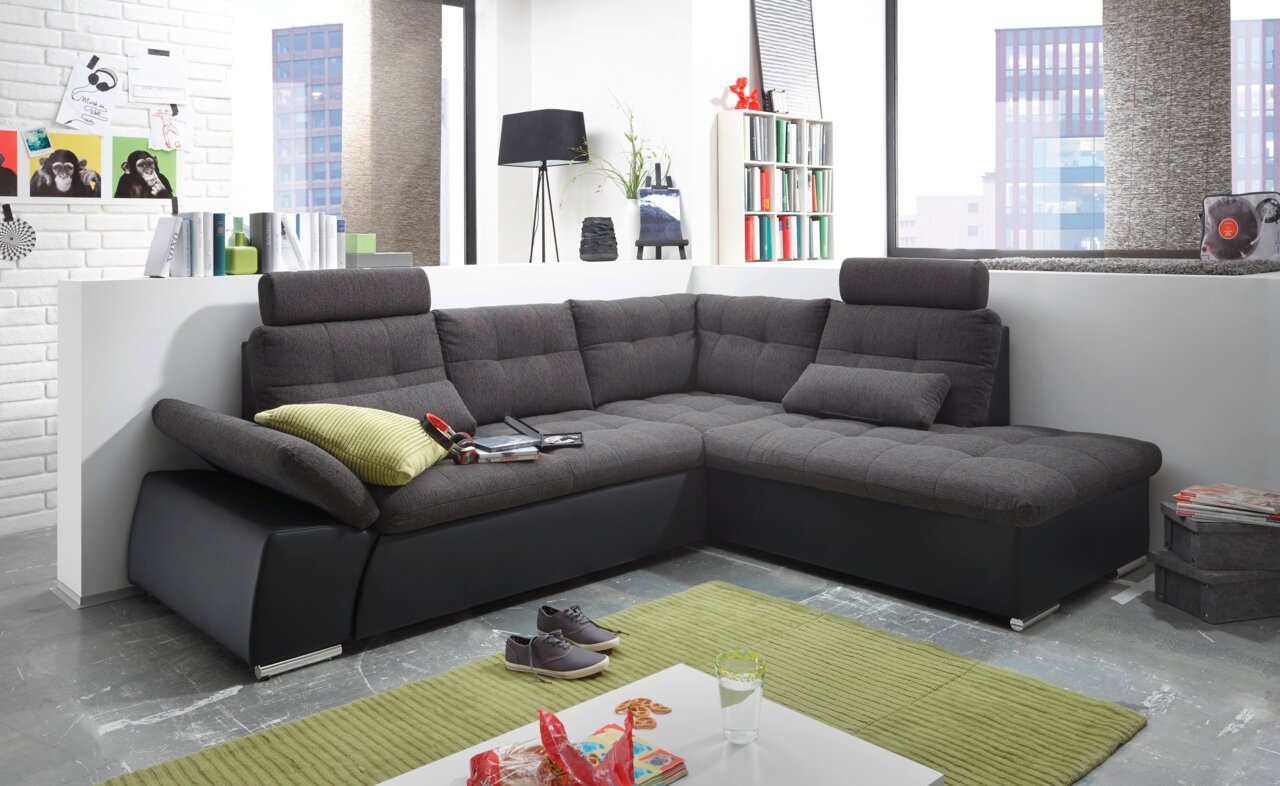 Moderne Rundecke in einem hellen Wohnzimmer, mit grauem Stoffbezug und schwarzen Lederakzenten, aus der Perspektive von vorne links.