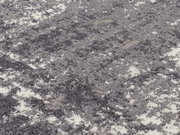 Nahaufnahme eines Designer-Teppichs mit grauem und weißem Muster, aus seitlicher Perspektive fotografiert.