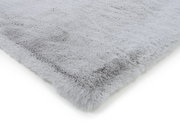 Grauer Fellteppich in Nahaufnahme, perspektivisch von der Seite fotografiert.