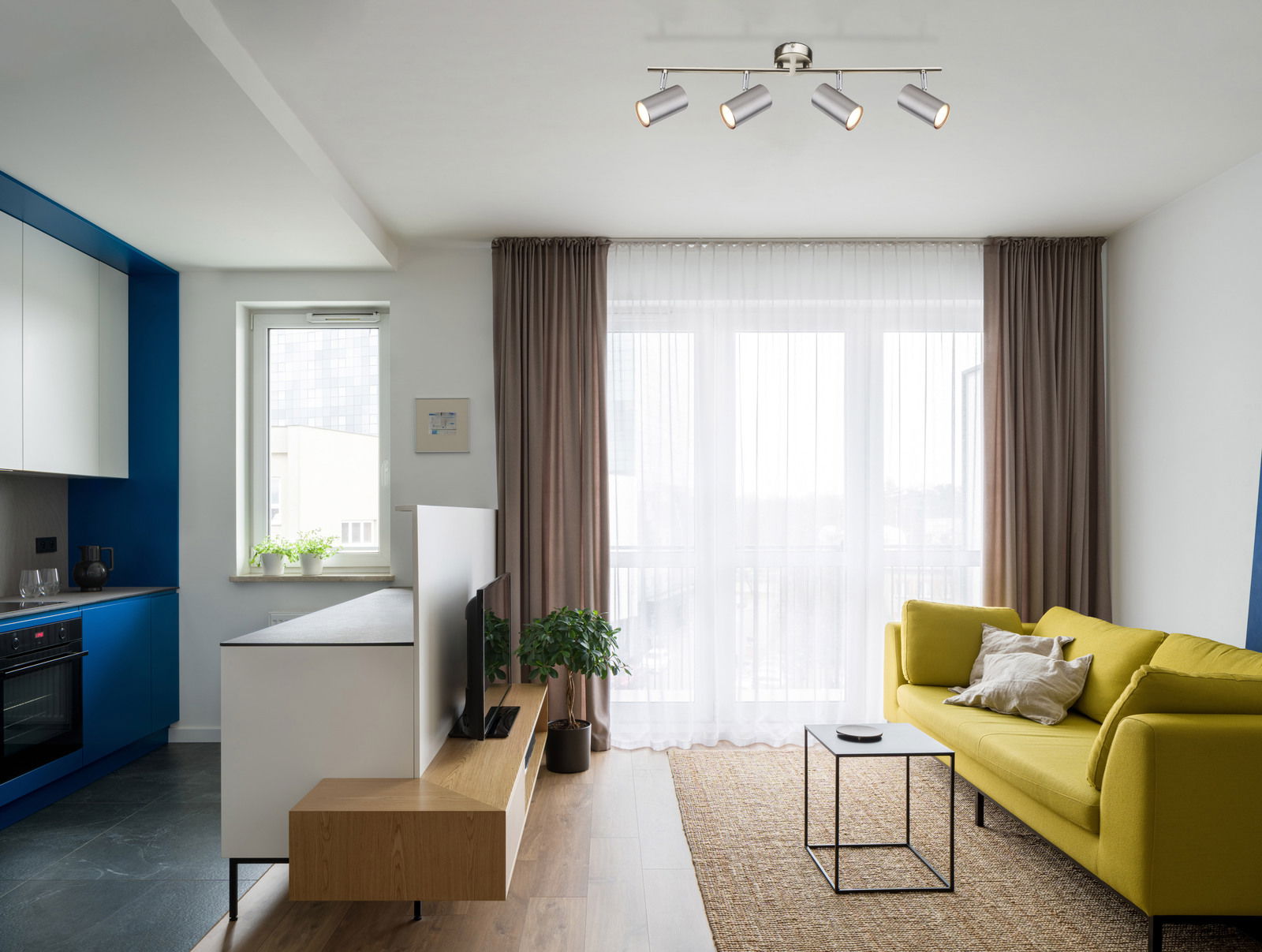 Moderne Deckenstrahler mit vier verstellbaren Leuchten in einem stilvollen Wohnzimmer aus der Vogelperspektive.