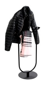 Schwarzer, freistehender Garderobenständer aus Metall mit rundem Standfuß und Ablageschale, von vorn leicht seitlich fotografiert, mit aufgehängter schwarzer Steppjacke und rosa-grau kariertem Schal vor weißem Hintergrund
