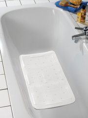 Witte badkuipbekleding in een badkuip, gefotografeerd van bovenaf.