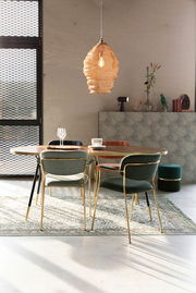 Esszimmer mit einem runden Tisch und mehreren Armlehnenstühlen in verschiedenen Farben, von hinten betrachtet. Im Hintergrund eine moderne Hängelampe und Dekorationen.